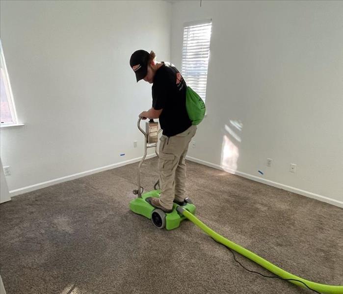 Picture of our technician extracting water from carpet.